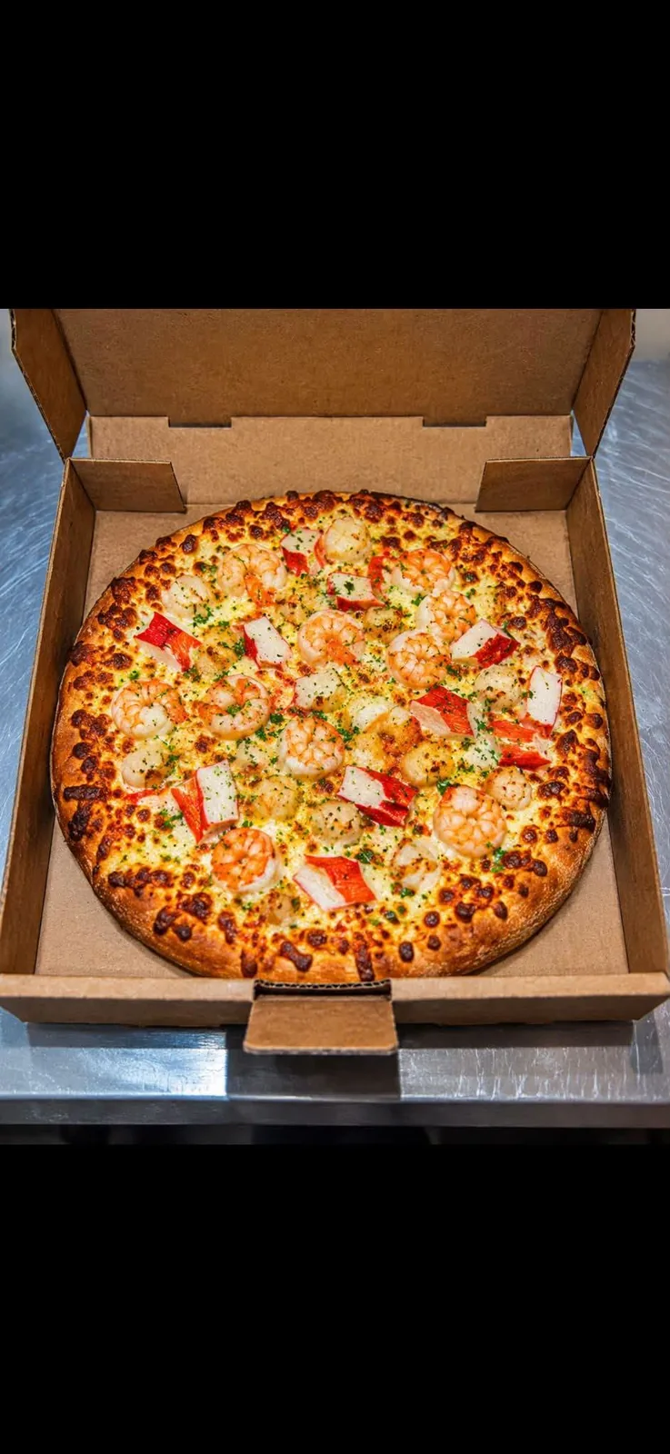 Pizza aux crevettes et à la goberge sur fond blanc, dans sa boîte ouverte.